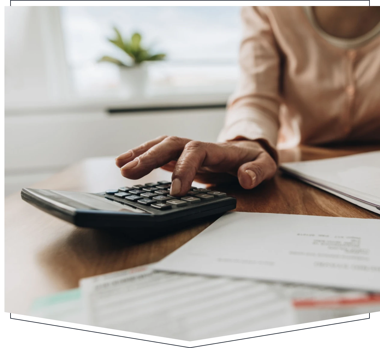 Person using calculator with documents nearby.